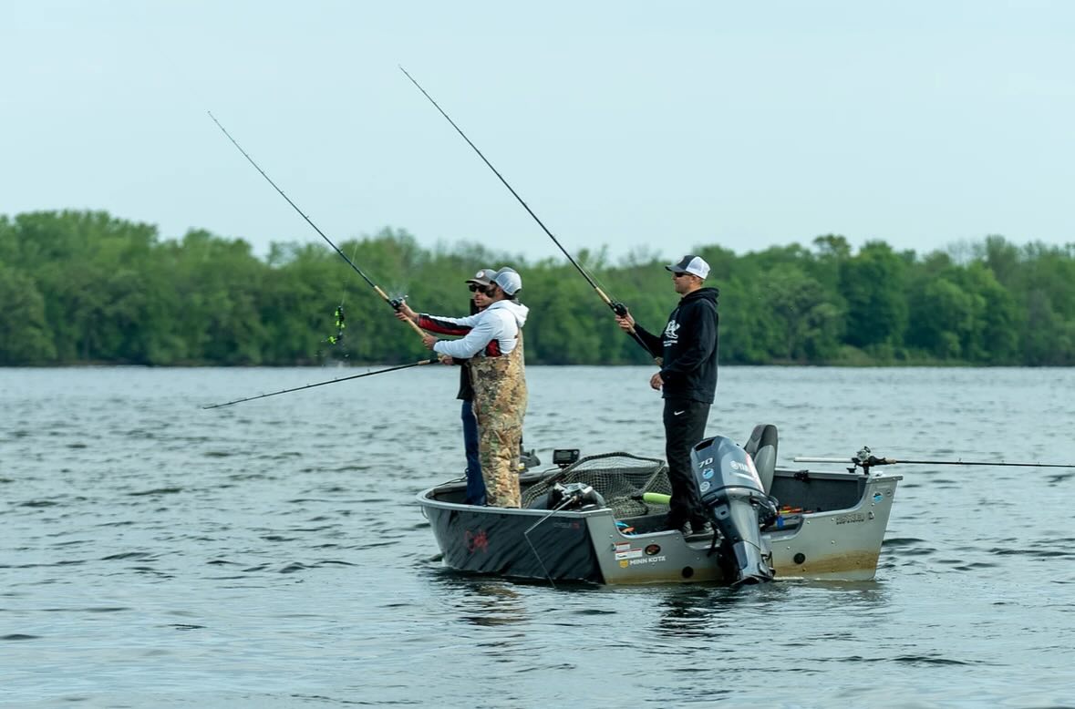 participants in the Casting for Kids tournament casting their reels from inside a boat that's on a lake