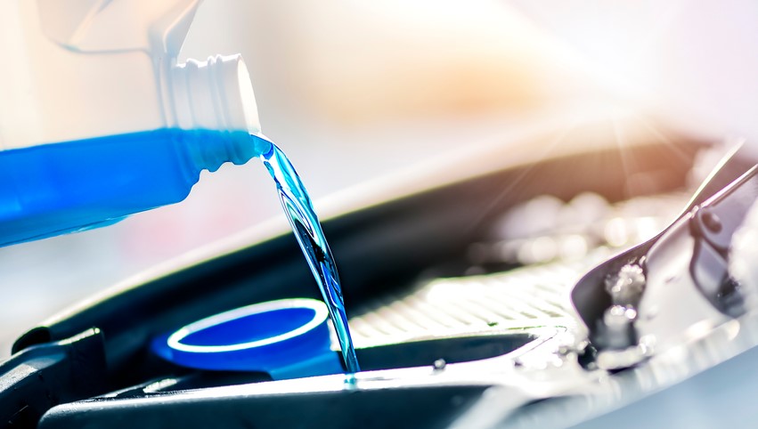 blue fluid being added to a vehicle's reservoir