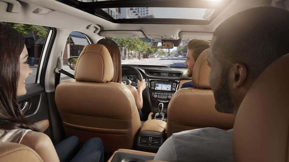Family riding in a 2017 Nissan Rogue under the panoramic moonroof