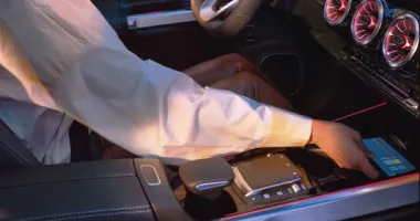 Person reaching for their phone in the front center console