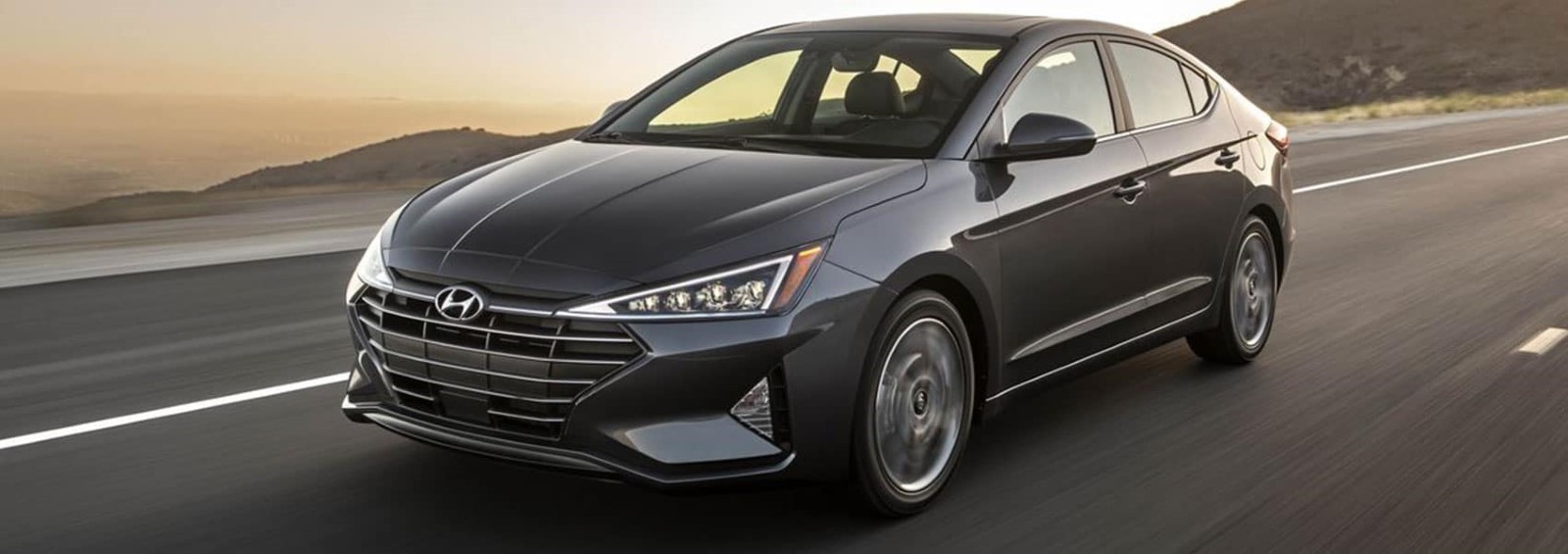A gray 2020 Hyundai Elantra driving down the road.