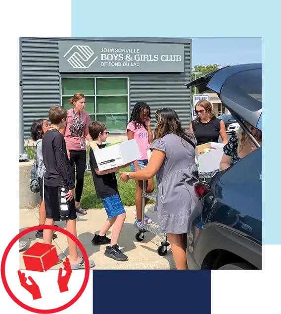 Holiday Automotive gives where we live. Image of Holiday team members delivery school supplies to Fond du Lac Boys and Girls club