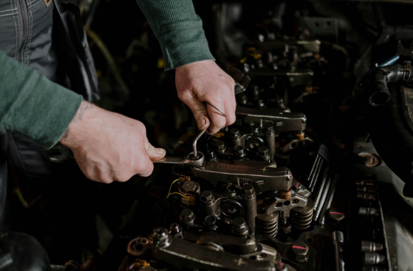 A close-up shot of an auto mechanic maintaning the car engine