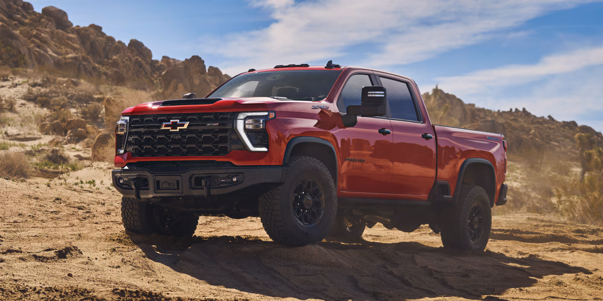Red Chevy Silverado 2500HD HD pickup truck with off-road tires available for sale at Joe Cooper Chevrolet GMC Cadillac of Shawnee, Oklahoma