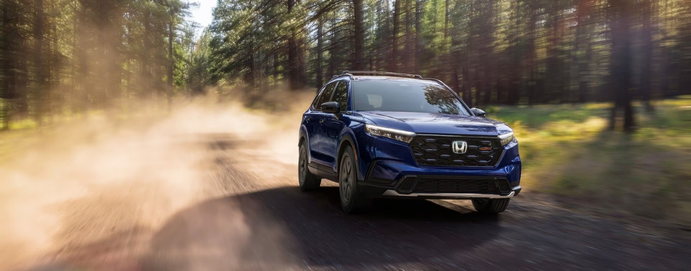 A blue 2026 Honda CR-V TrailSport Hybrid off-roading.