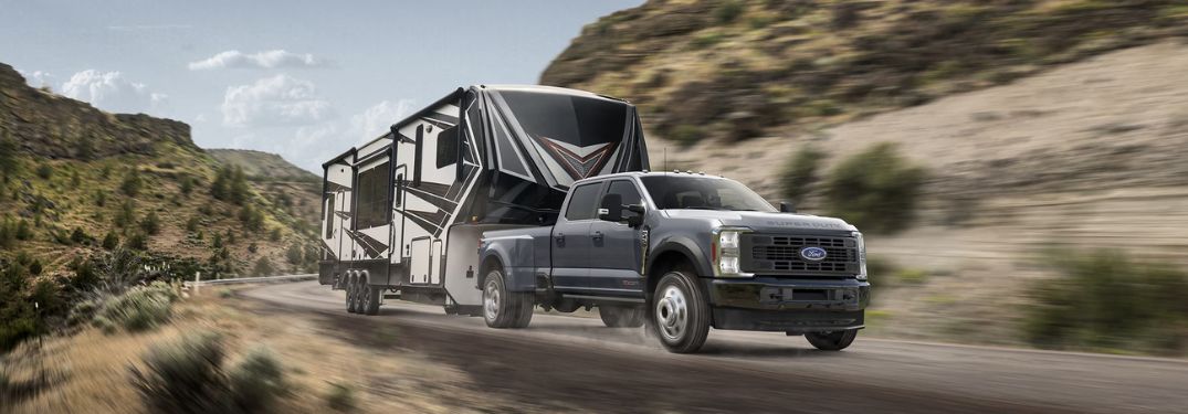 Gray 2025 Ford Super Duty Towing a 5th-Wheel Trailer on a Mountain Road