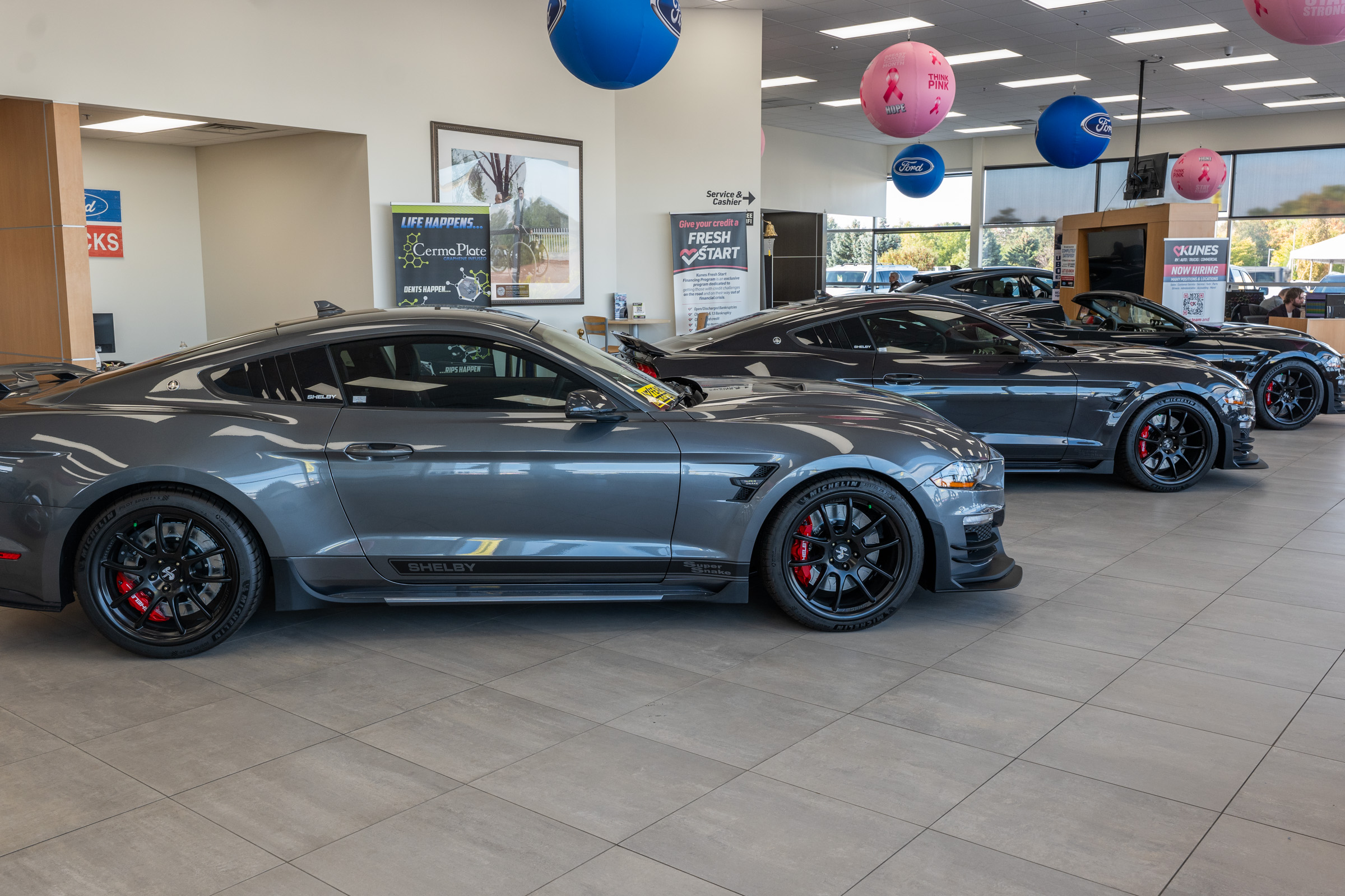 Gray Ford Mustang Shelbies parked in a line inside of a Kunes dealership