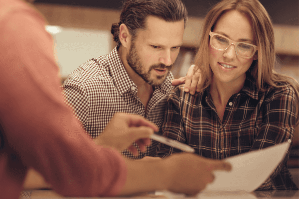 Couple reviewing financing paperwork with a salesperson