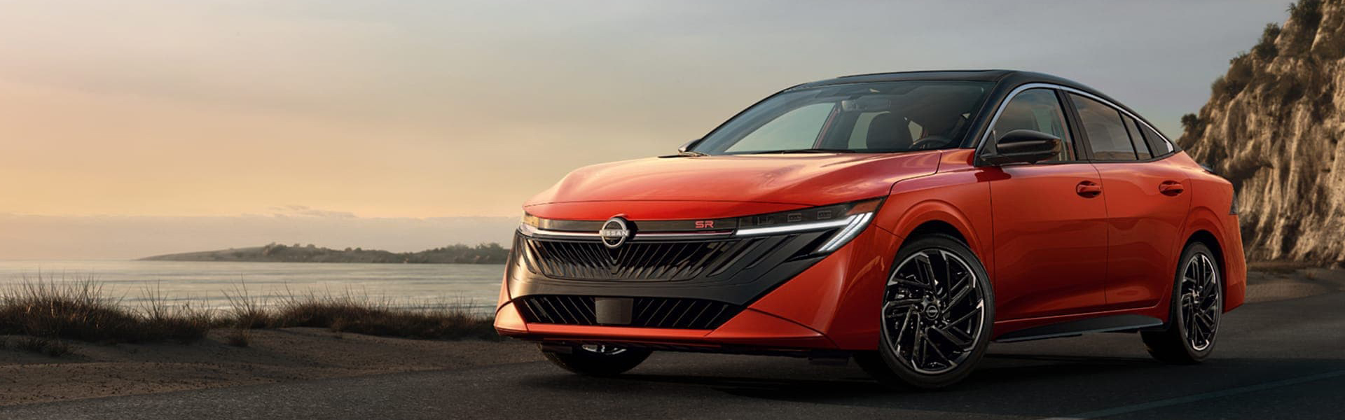 2026 Nissan Sentra Redesigned Front Grille On Display On A Coastline Banner
