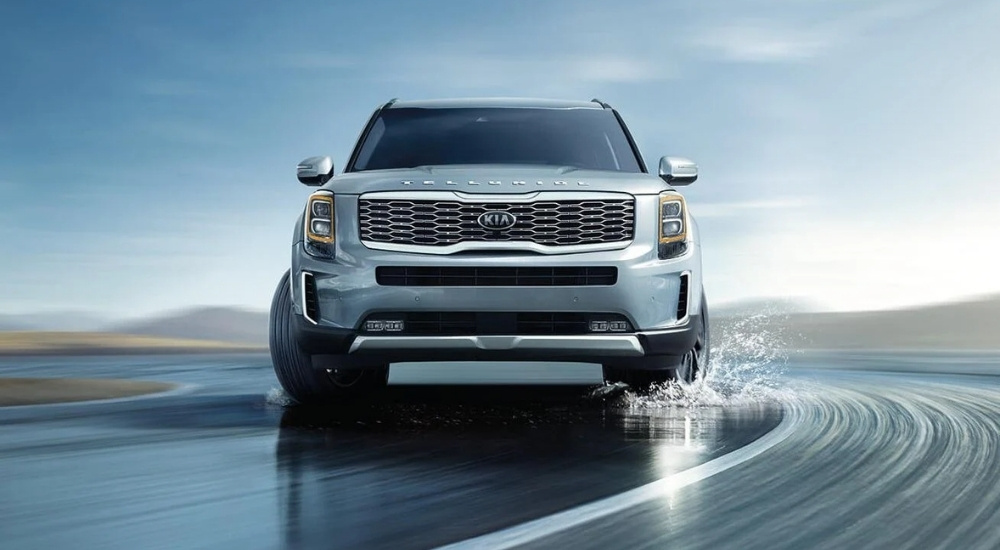Silver 2021 Kia Telluride is shown driving to a used Kia dealer