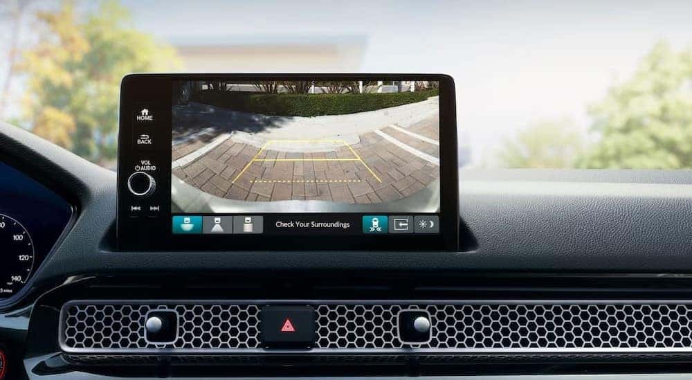 A close-up of the infotainment screen is shown in a 2025 Honda Civic Sport.