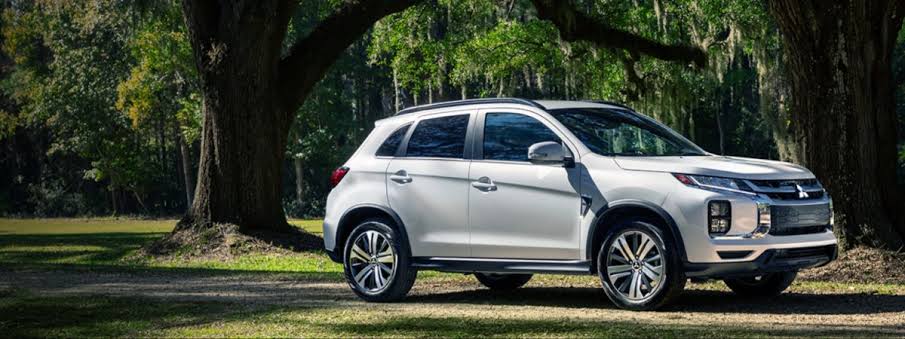 2027 Mitsubishi Outlander Sport in white parked beneath large oak trees