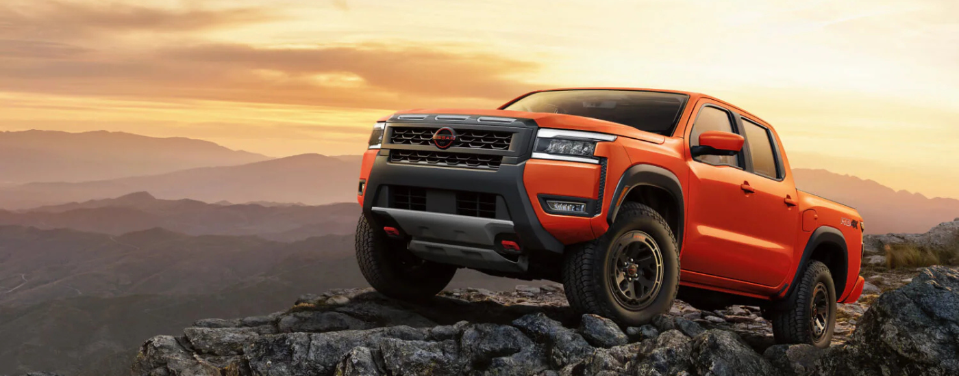 Orange 2026 Nissan Frontier parked off-road