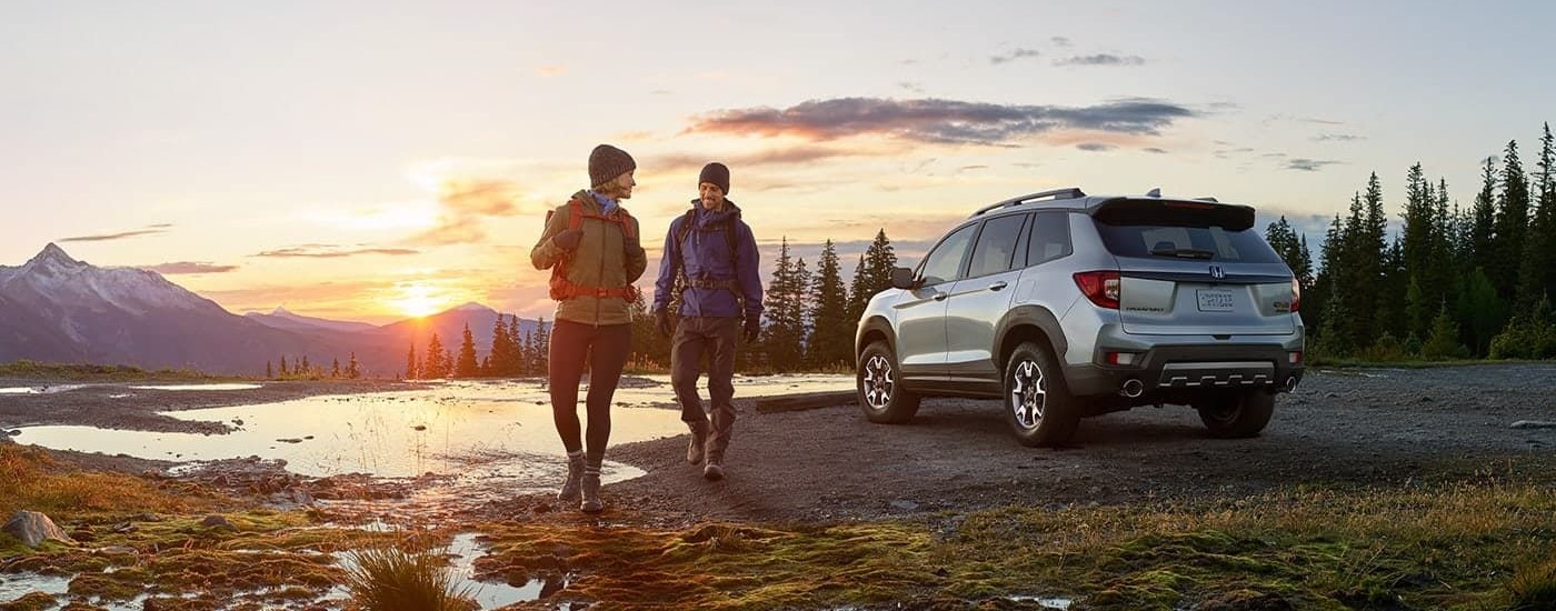 Hikers near a silver 2022 Honda Passport Trailsport