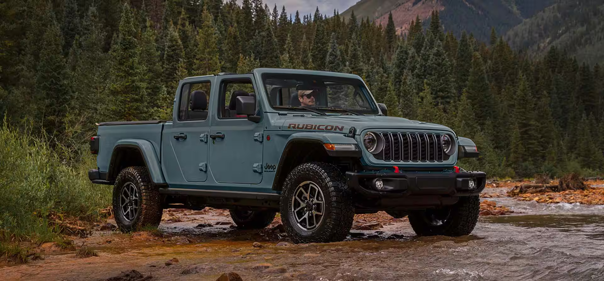 A man sitting in a jeep gladiator.