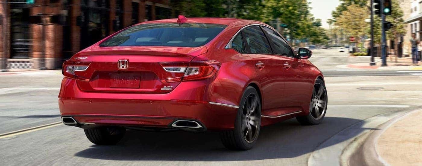 A red 2021 Honda Accord Touring 2.0T is shown from the rear on a city street.