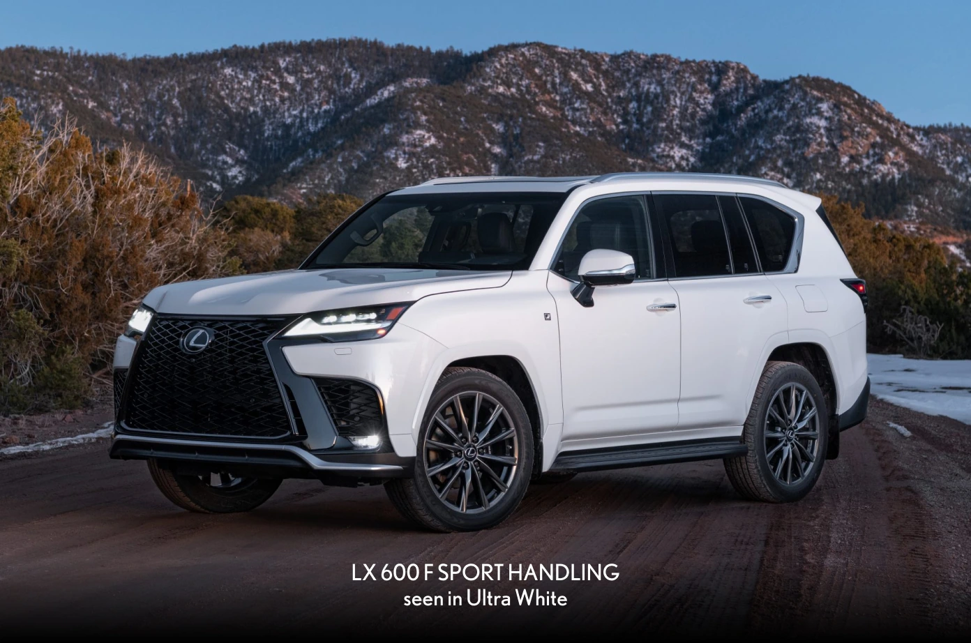 2026 Lexus LX 600 F SPORT Handling in Ultra White, front three-quarter view on a mountain road at dusk.