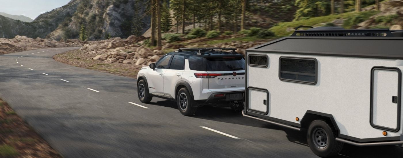 White 2026 Nissan Pathfinder Rock Creek towing a trailer