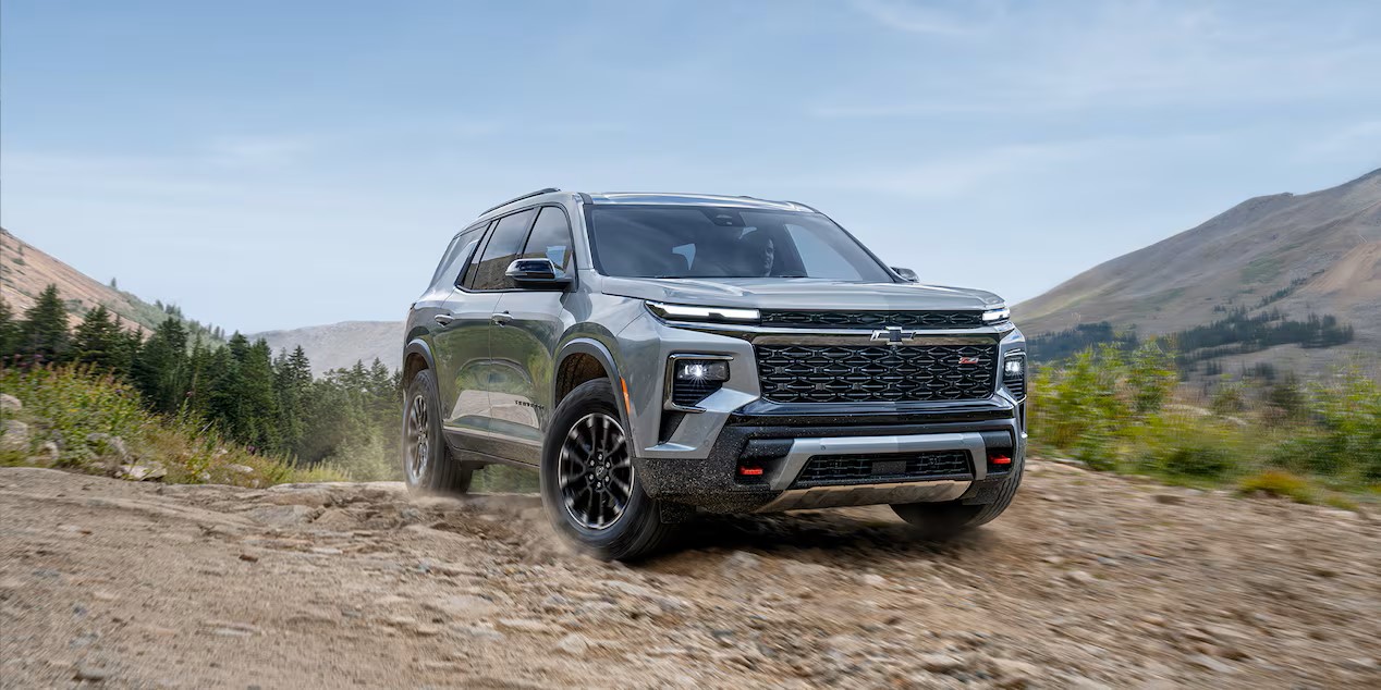 a gray suv driving in the mountains on rocky roads