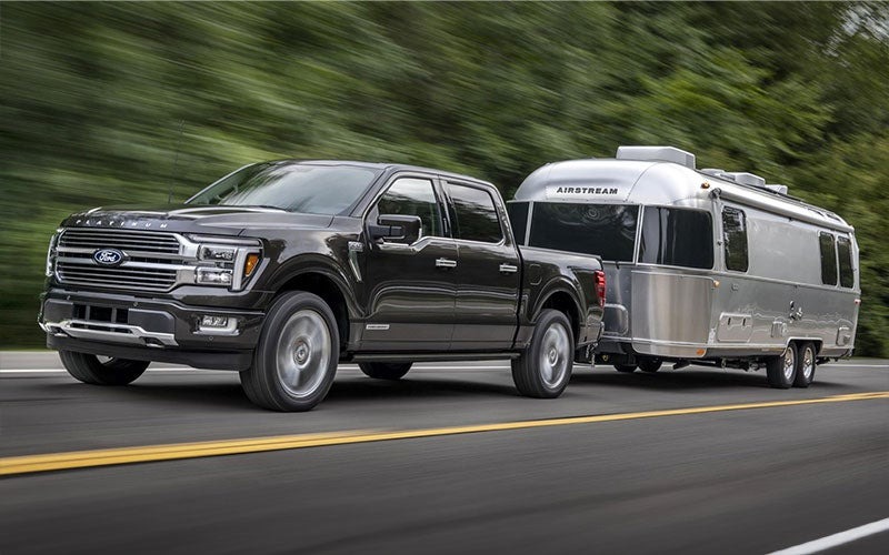 image of black ford f-150 towing trailer