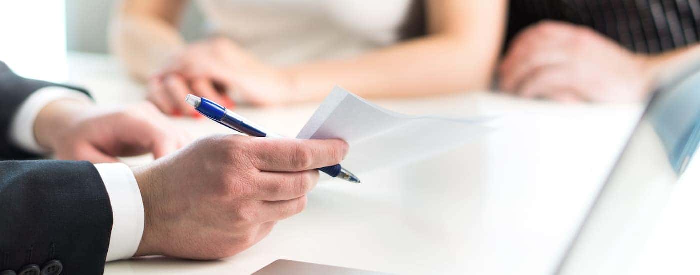 A salesman is going over the auto loan with a couple.