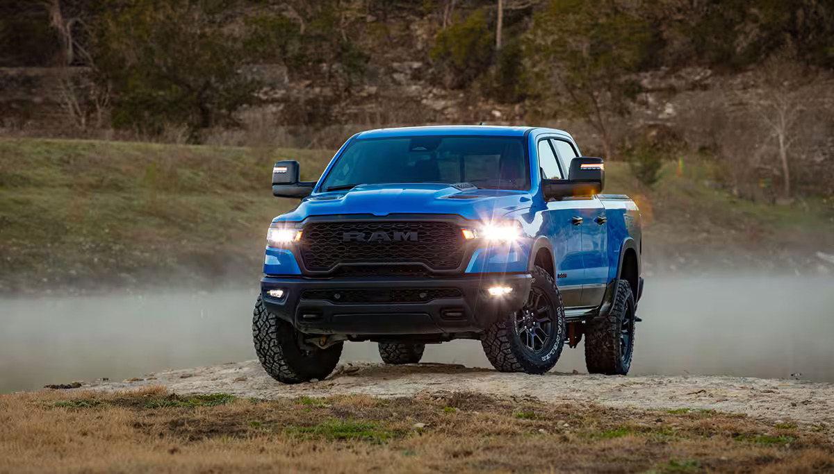 A blue ram 1500 on a dirt road.