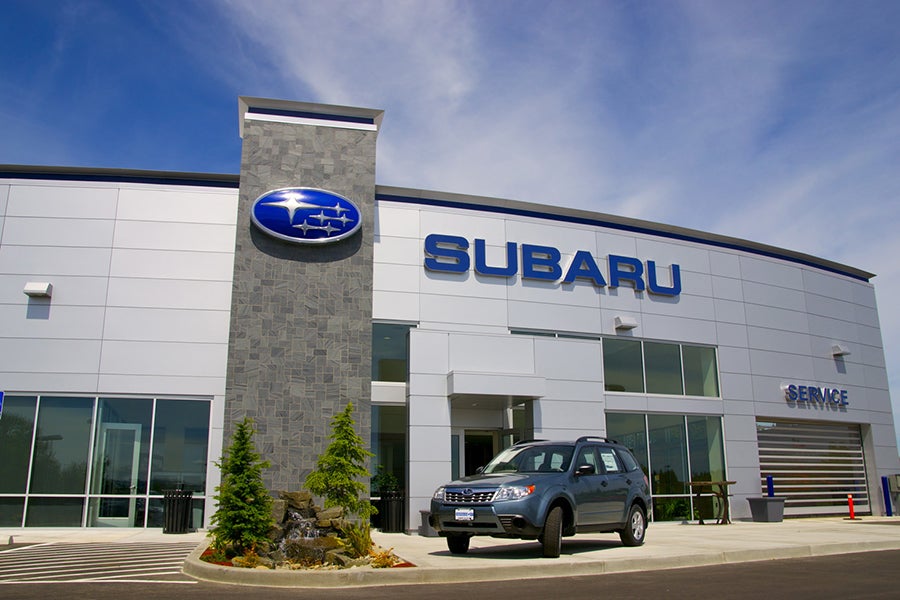 Subaru dealership building with the Subaru logo and a Subaru SUV parked out front
