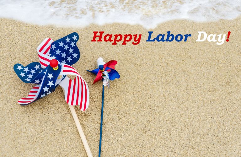 American Flag Pinwheels and Happy Labor Day Text on a Beach