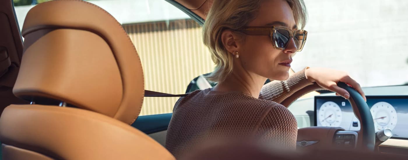 Woman driving in a 2026 Genesis GV80