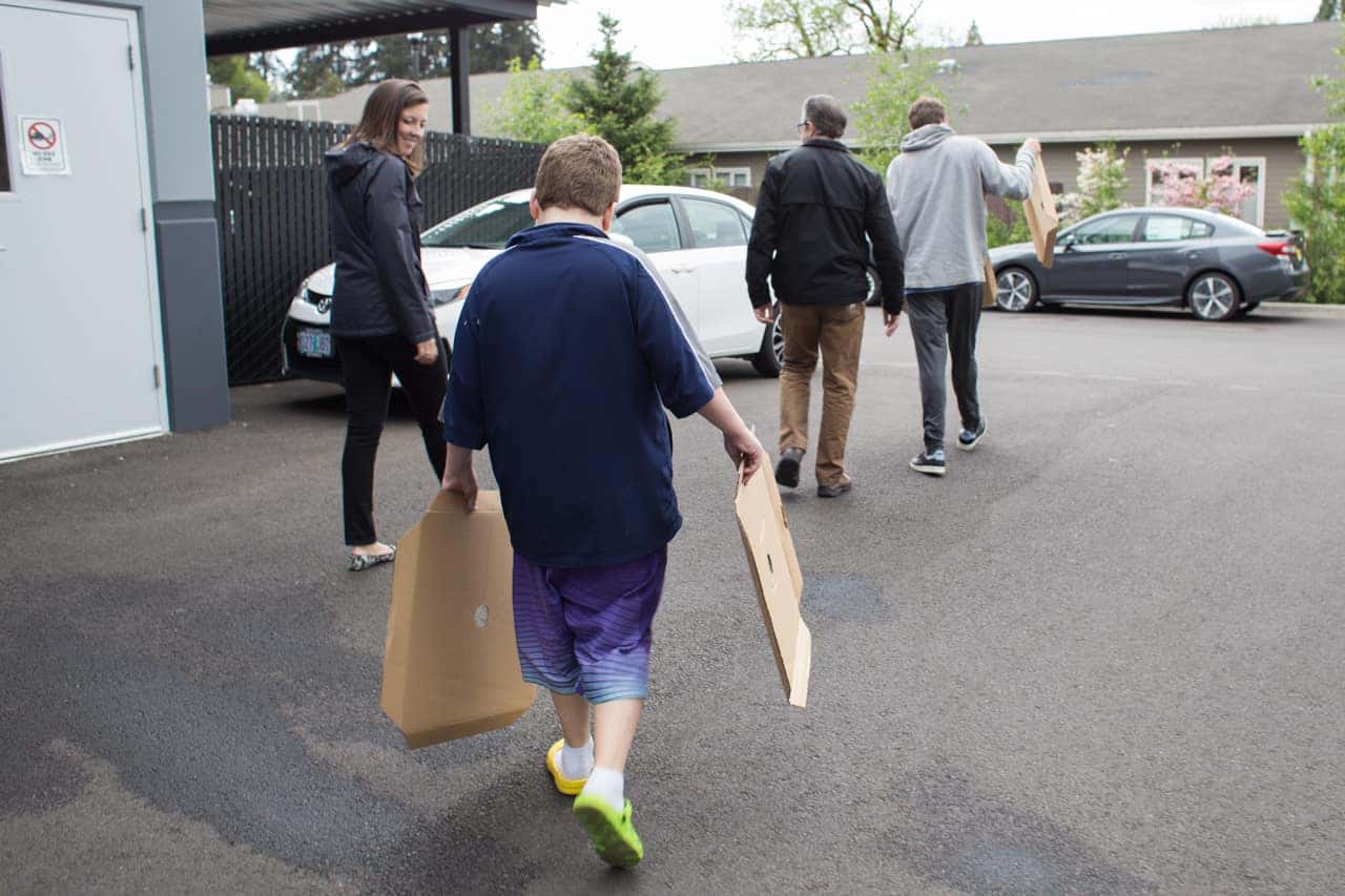 Victory Academy students carrying bags across a parking lot