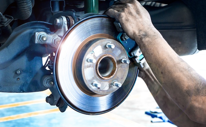 Auto brake service being completed by an auto service tech.