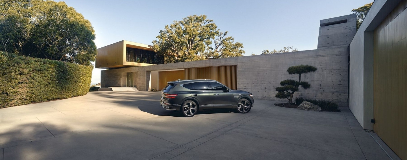 Grey 2026 Genesis GV80 parked in front of a home