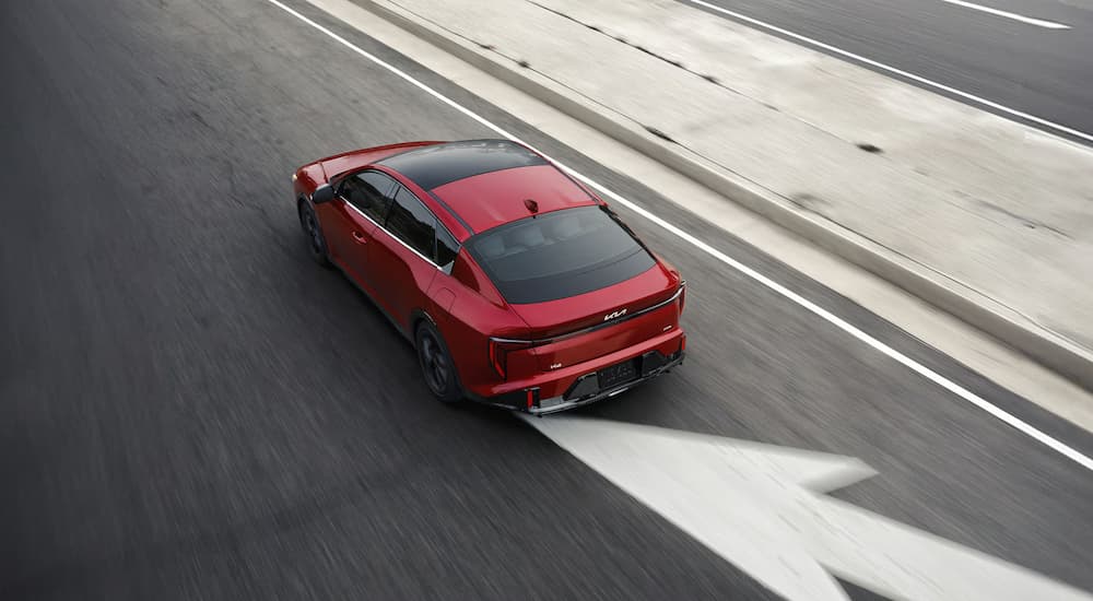 Red 2026 Kia K4 driving on a highway