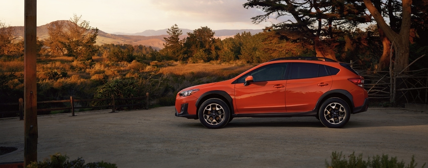 An orange 2020 Subaru Crosstrek Premium parked on a gravel lot.