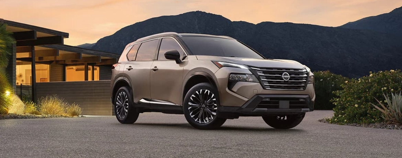 Tan 2025 Nissan Rogue parked near a house