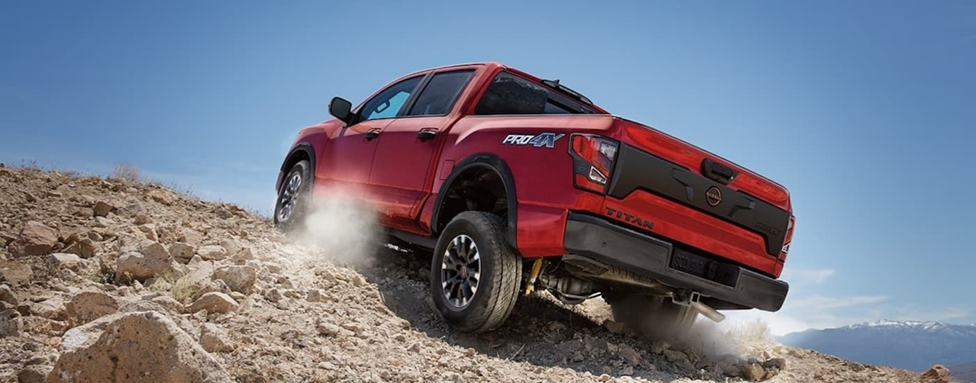 Red 2024 Nissan Titan PRO-4X driving up a dirt hill