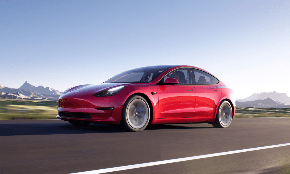 A red luxury electric car driving down a highway.