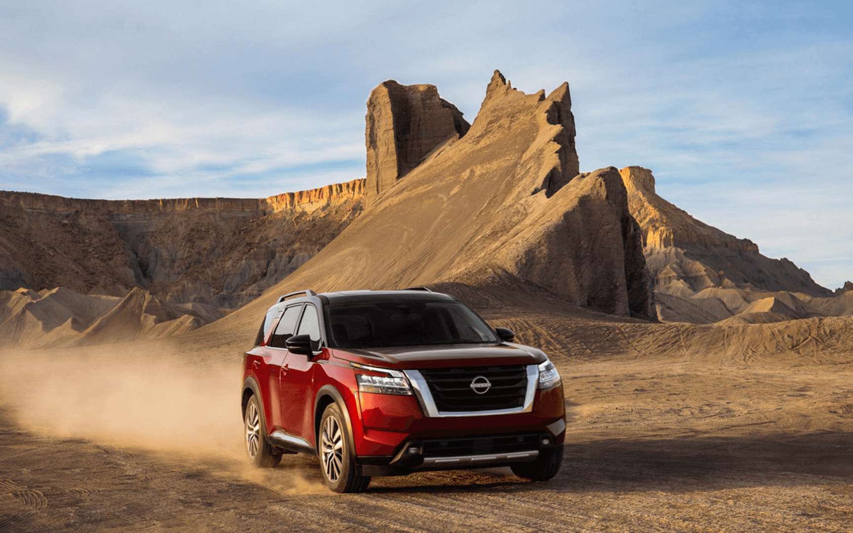 Red Nissan Pathfinder driving through the desert