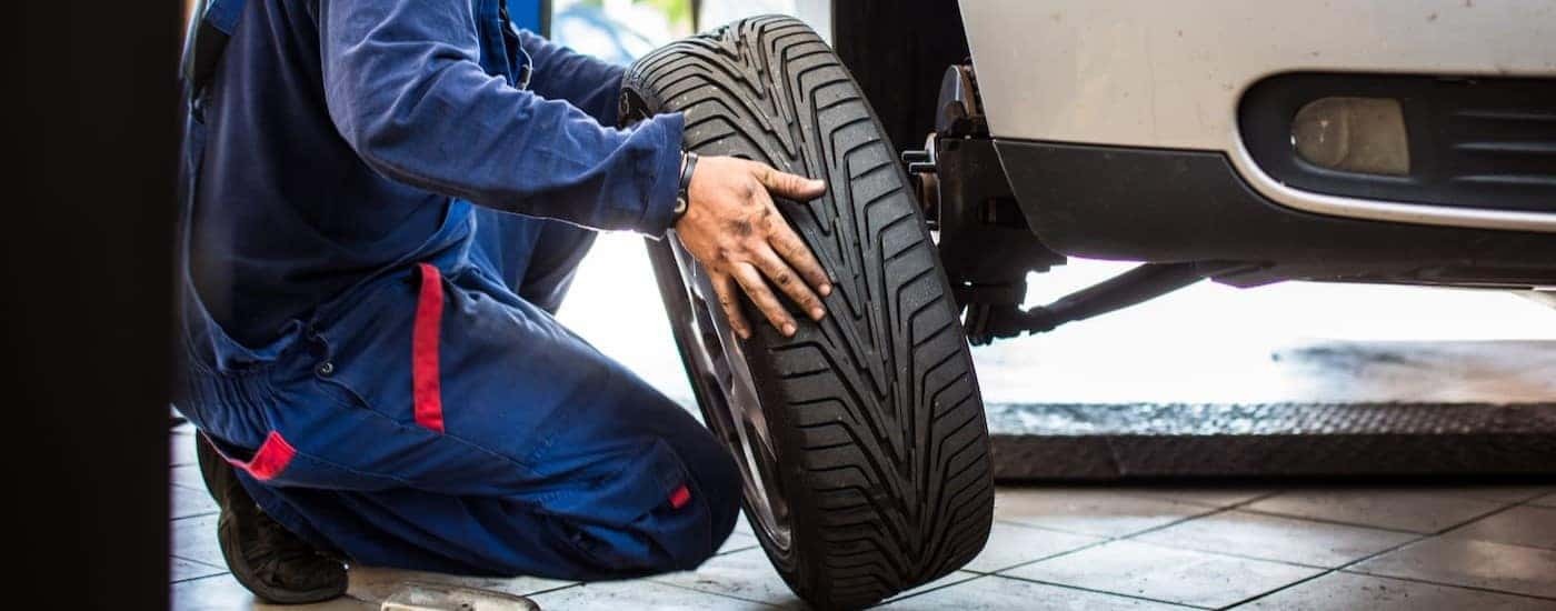 A mechanic is shown removing a tire from a vehicle.