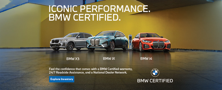 BMW Certified X3, iX, and i4 parked next to a colorful building wall.