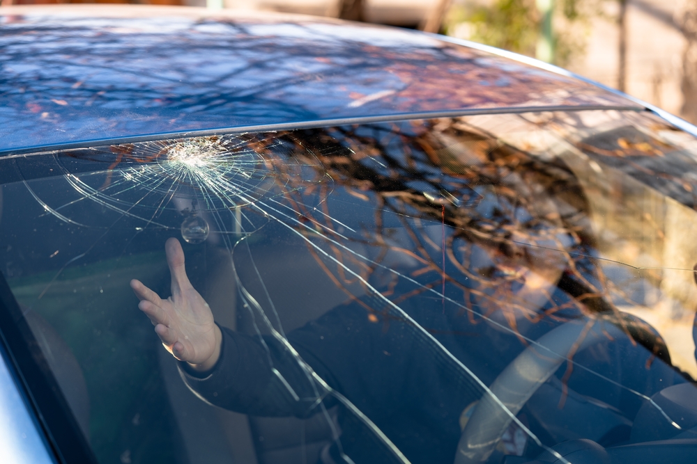 woman inside vehicle concerned about her cracked windshield