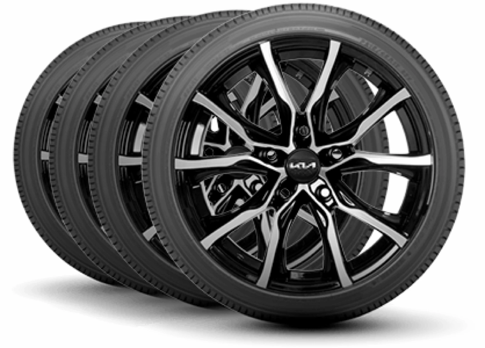 Four black machined-face Kia alloy wheels with tires, mounted in a row against a white studio background.