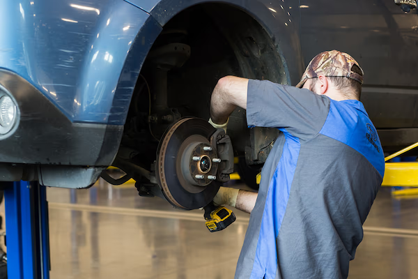 Subaru technician working on a wheel and brake assembly