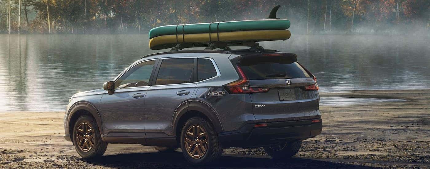 A gray 2025 Honda CR-V EX HPD Edition is shown parked near a lake.