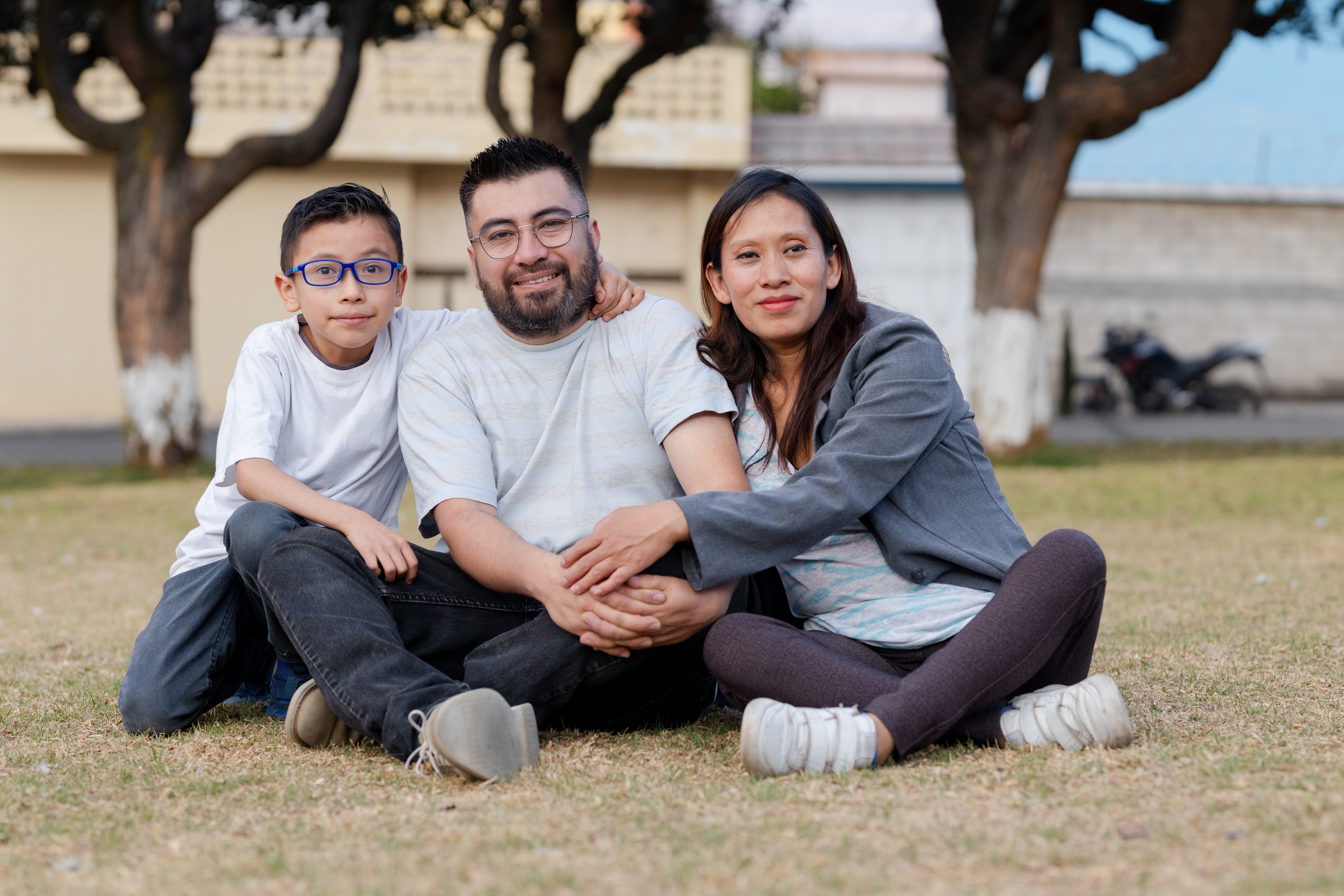 Hispanic family in the countryside- small family of three enjoying in a natural park. happy family hugging in nature. latin american family