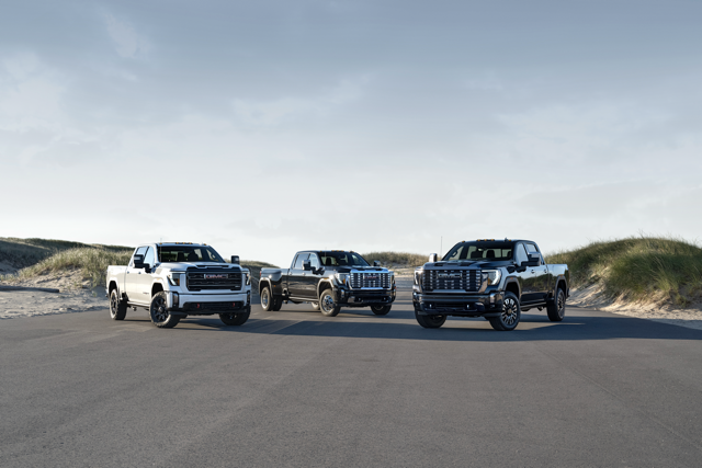 Three GMC Trucks parked on a road