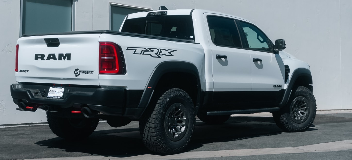 Rear view of a white 2027 Ram 1500 TRX SRT with TRX bedside graphic
