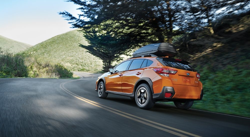 An orange 2020 Subaru Crosstrek Premium driving.