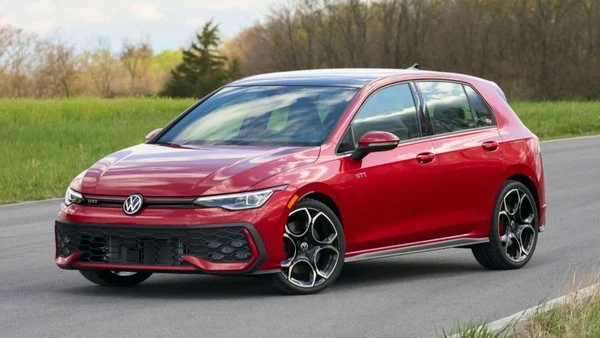 2027 Volkswagen Golf GTI in red, front three-quarter view on a country road