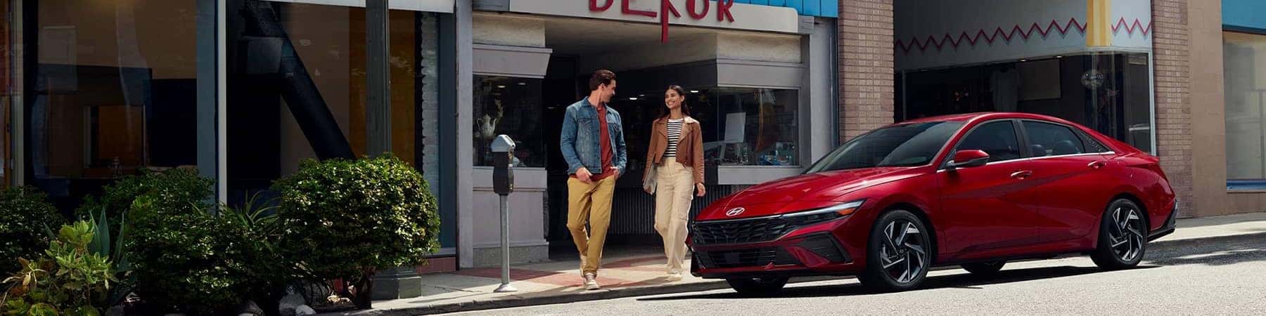 Hero Image of a red Hyundai sedan parked in front of a shopping store.